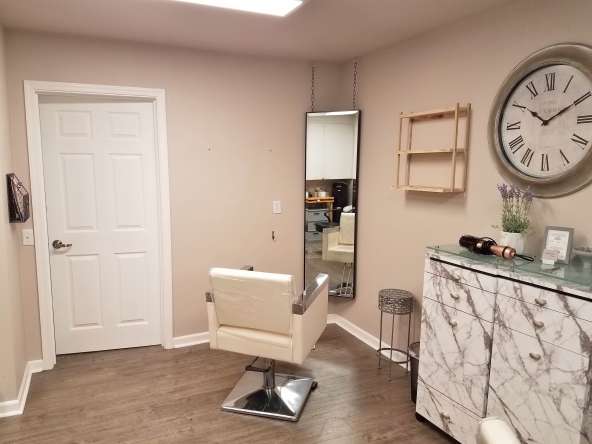 Bright salon styling station with mirror and beige walls at Salon Renter.