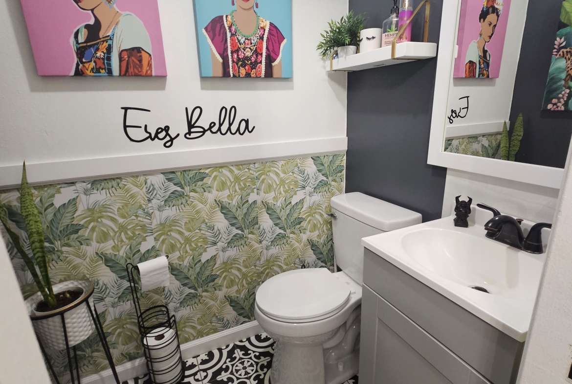 Colorful bathroom with floral and Frida Kahlo artwork, modern accents, and decorative details for salon-inspired space.