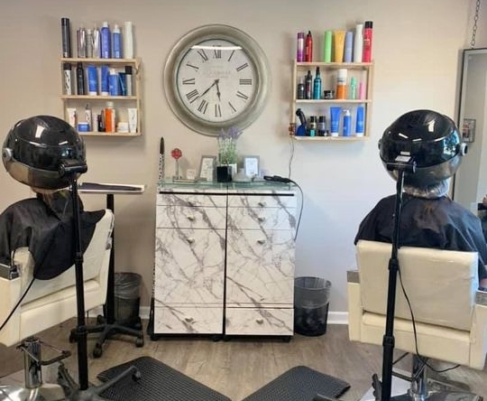 High-quality hair salon station with two chairs, hair dryers, and decorated shelves for hair products.