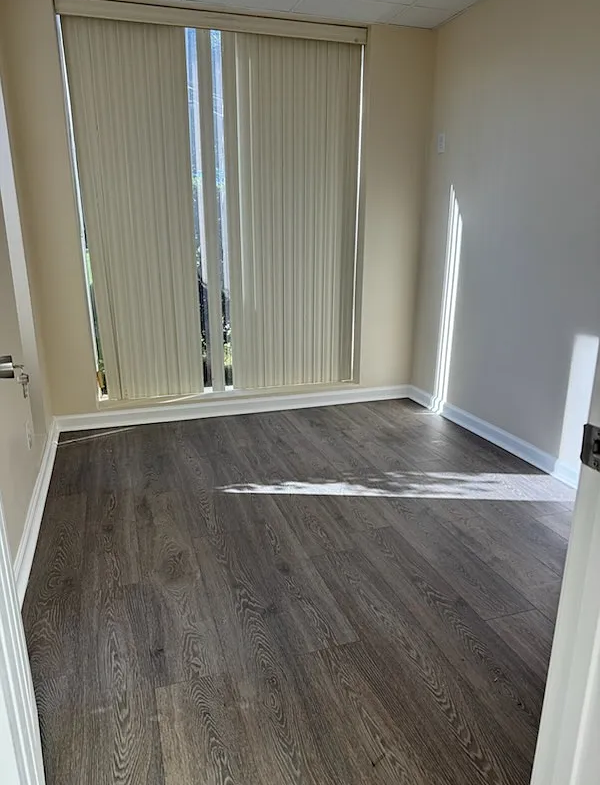 Bright, empty salon room with large window and vertical blinds, ideal for rent or startup hair styling business.