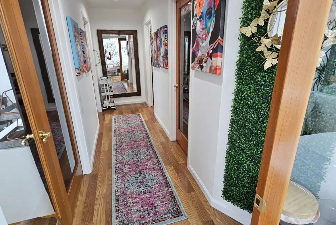 Bright hallway with colorful art and wooden accents, perfect for salon or beauty studio rental.