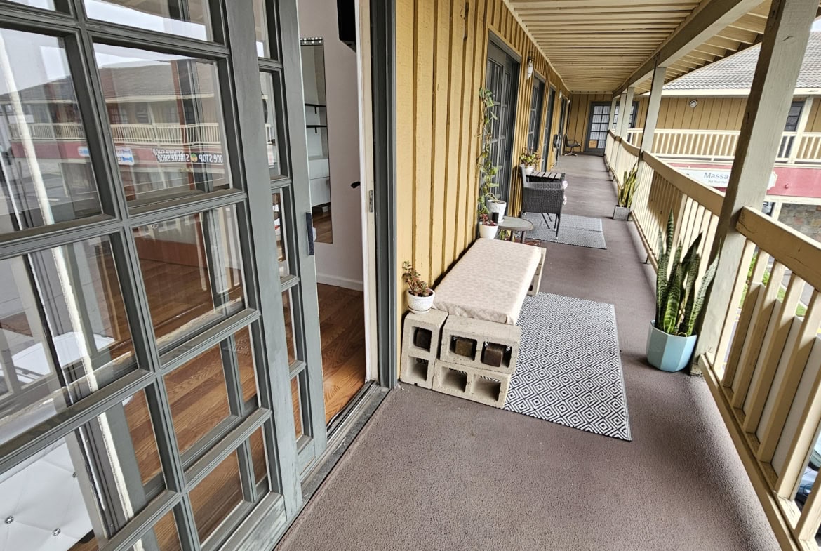 Spacious balcony with comfortable seating, potted plants, and decor at Salon Renter.