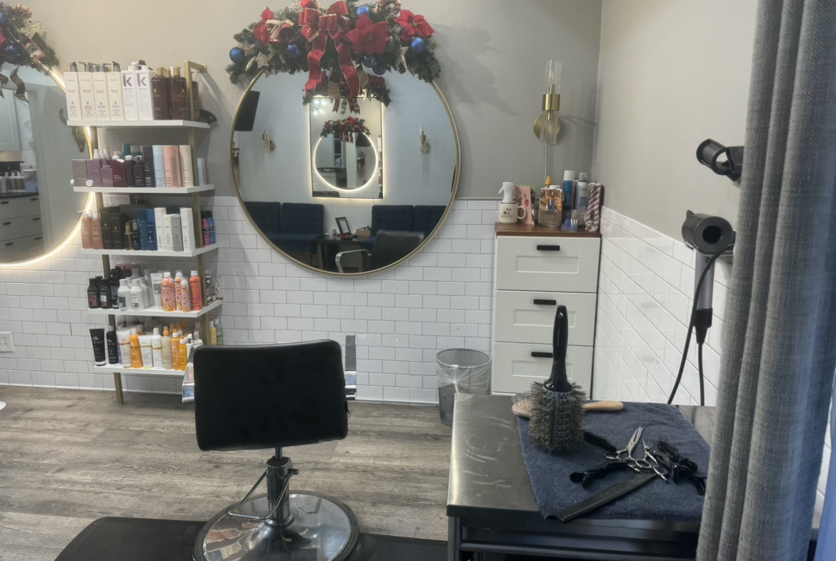 Modern salon station with mirrors, styling chairs, and product shelves.