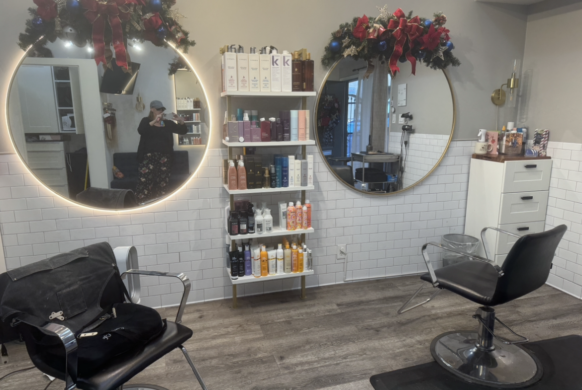 Decorative mirrors and modern salon furniture in a chic hair salon. Holiday wreaths add festive charm.