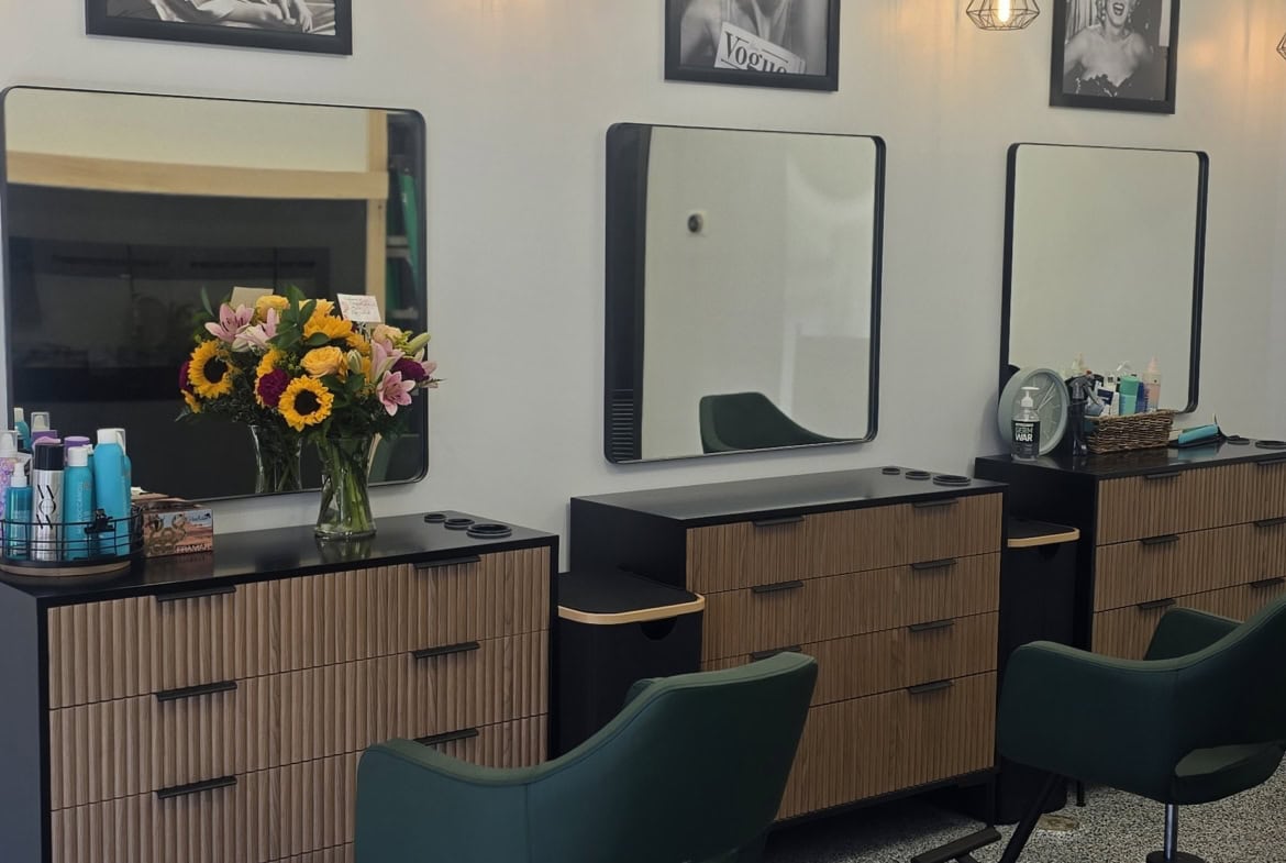 Salon interior featuring hair styling chairs, mirrors, and salon accessories.
