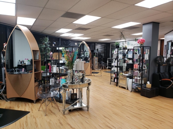 Spacious salon with hair stations, product shelves, and stylish decor for beauty services.
