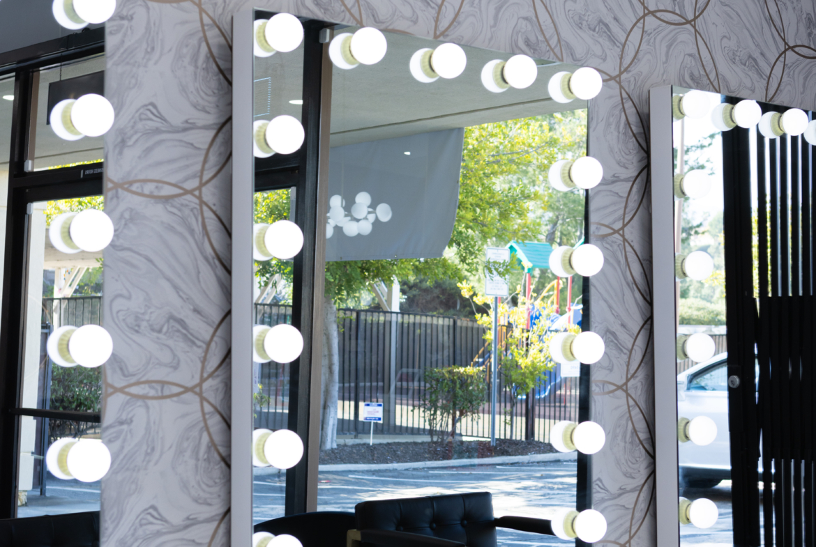Bright salon makeup mirrors with Hollywood-style bulbs.