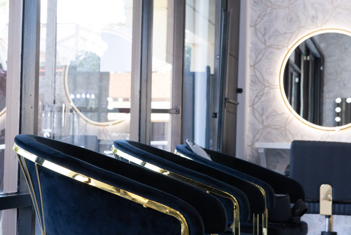 Stylish salon chairs with gold accents and velvet upholstery in modern beauty salon setting.