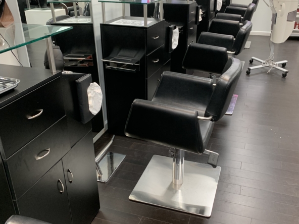 Modern salon workspace with styling chairs, mirrors, and hair care products for rent or lease.