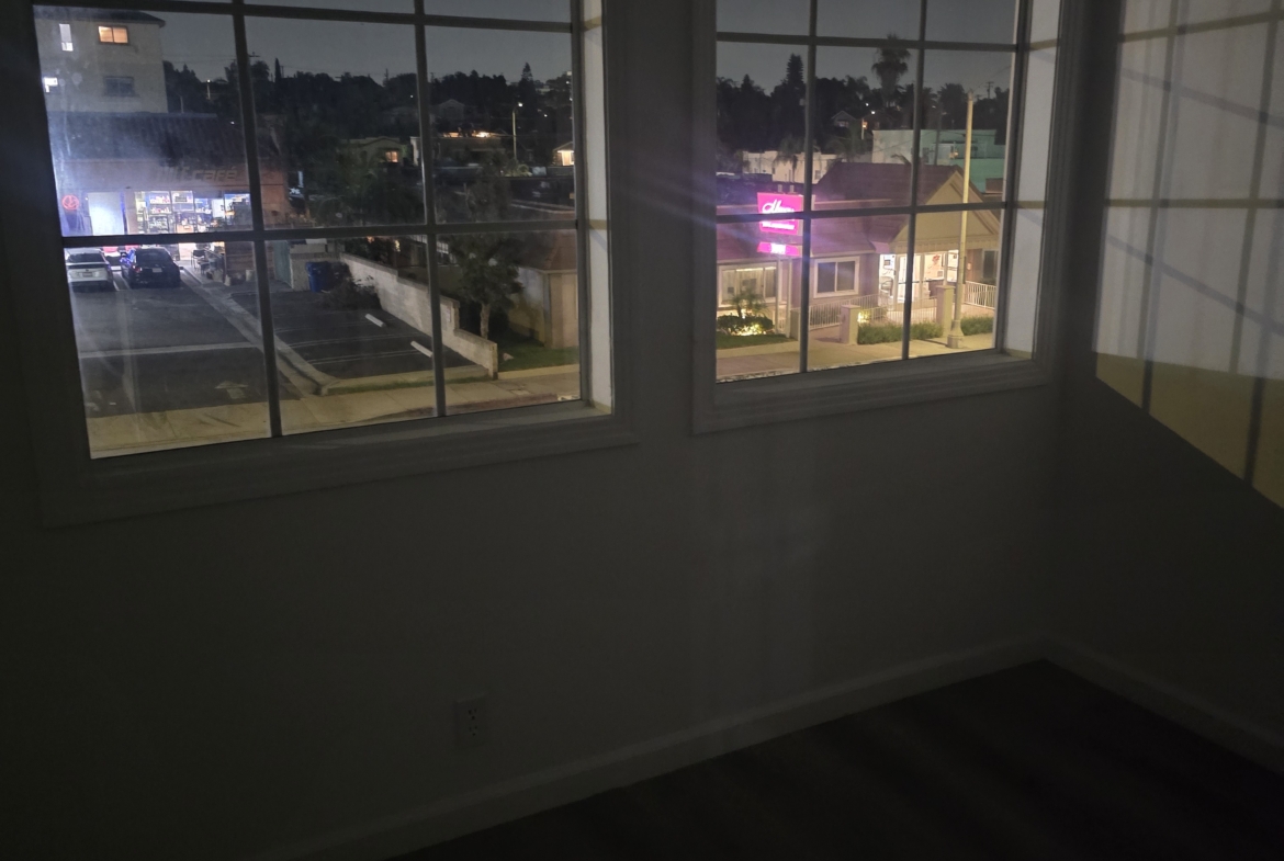 Bright city view from cozy apartment windows at night.