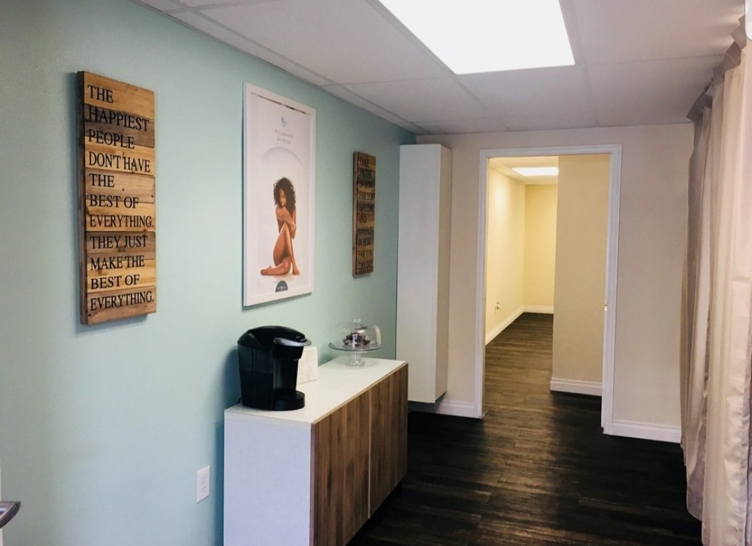 Bright salon waiting area with inspirational wall art and coffee station for clients.