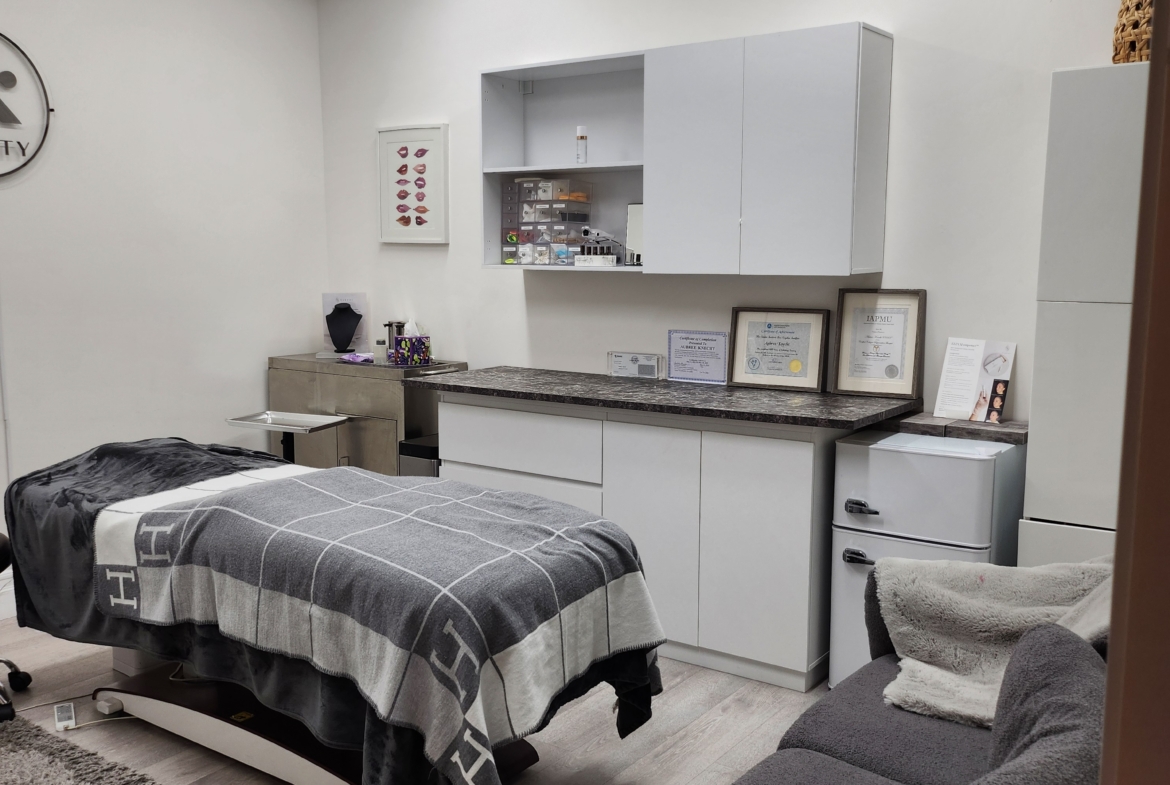 Salon Renter cleaning treatment room with massage table, storage cabinets, and cozy seating.