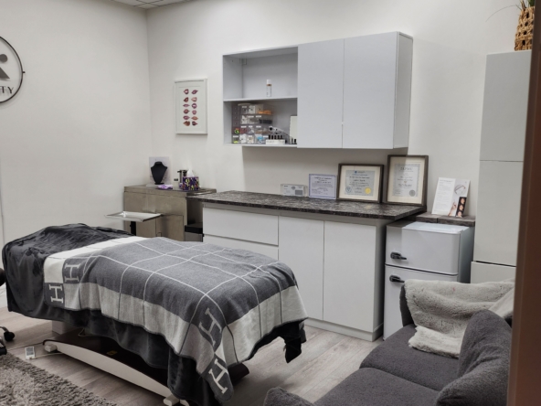 Salon Renter cleaning treatment room with massage table, storage cabinets, and cozy seating.