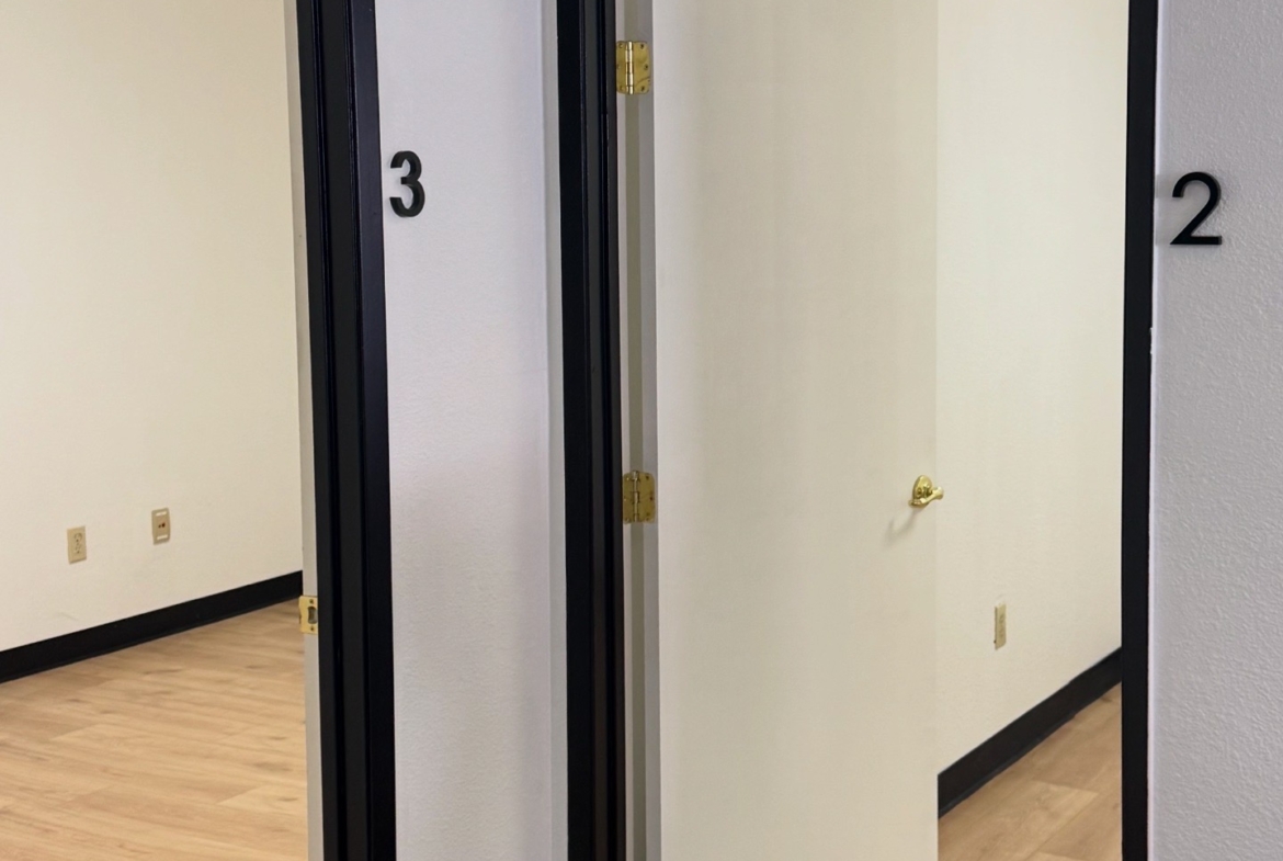 Elegant white and black framed doors for salon suite rentals, perfect for salon professionals seeking a private workspace.