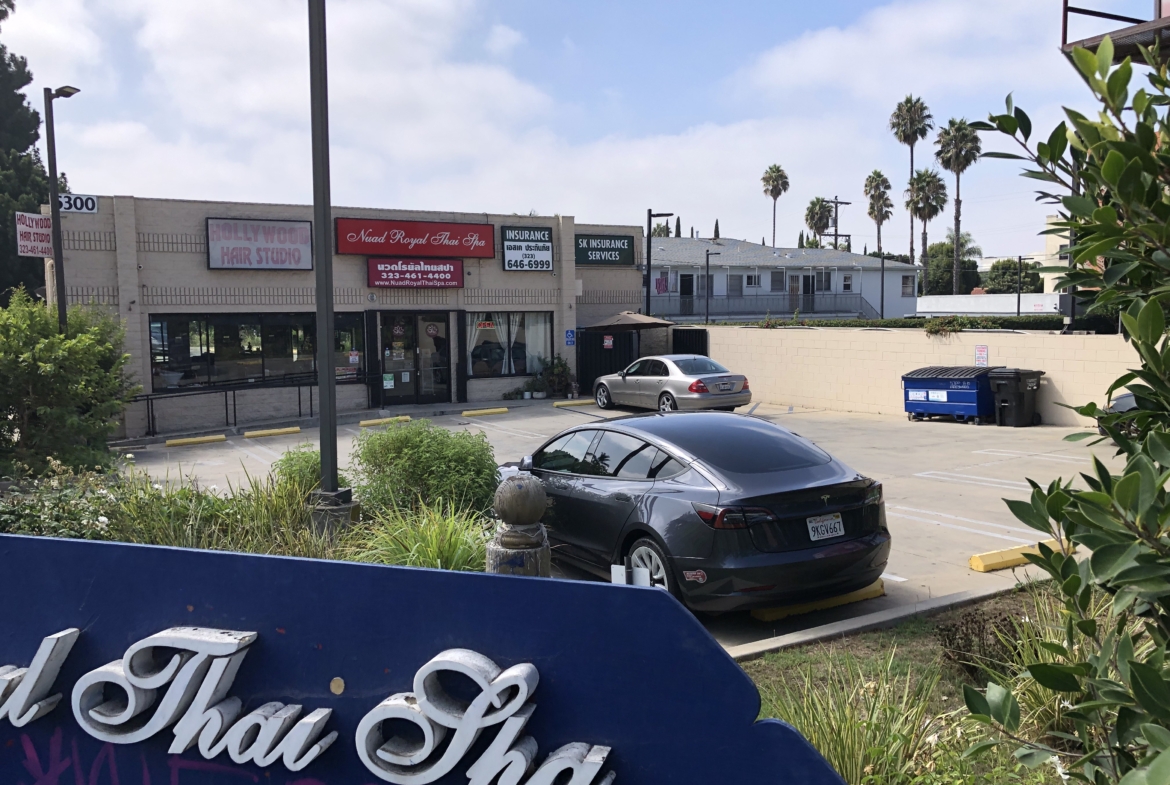 Salon Renter digital signage and storefront in a commercial shopping center with parking lot.