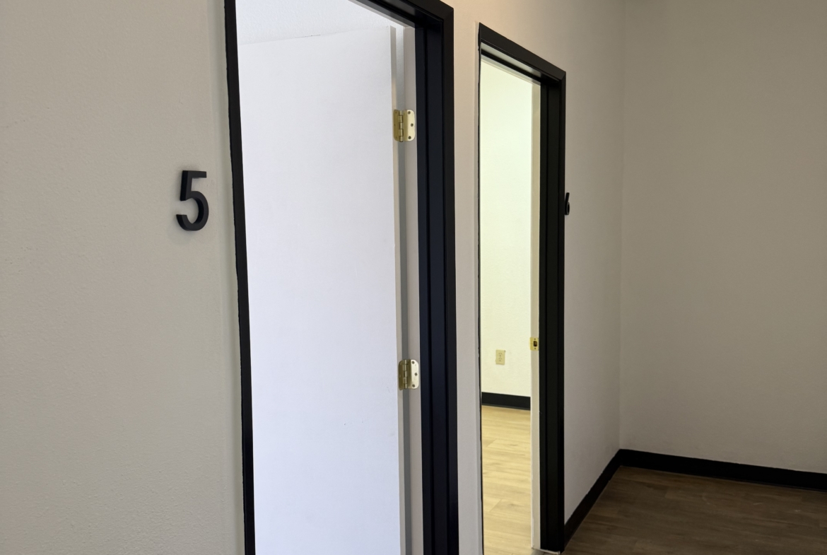 Clean, small salon renter rooms with white doors and black frames. Perfect for beauty or hair salon professionals.