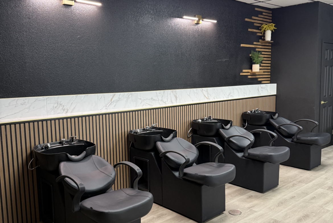 Modern black wash basins at salon rinse stations.