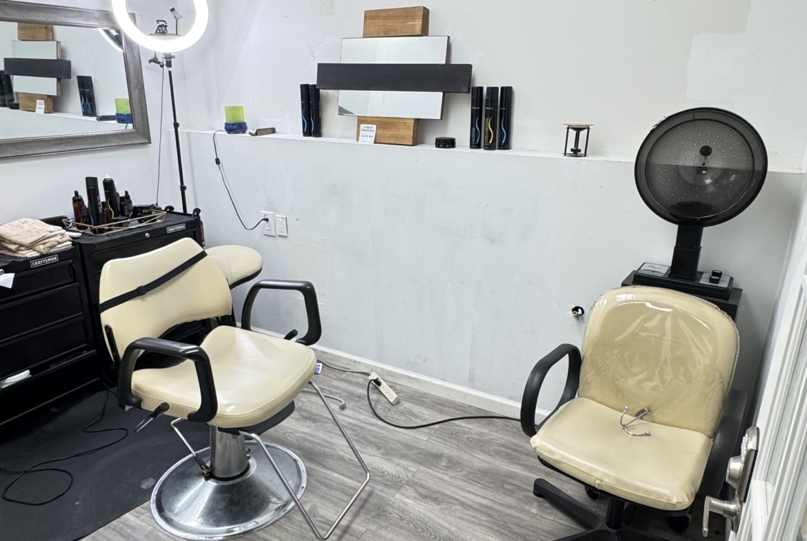Stylish salon workspace with chairs, mirror, hair tools, and professional lighting for rent.