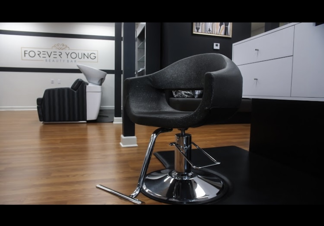 Comfortable black salon chair in a stylish hair salon interior.