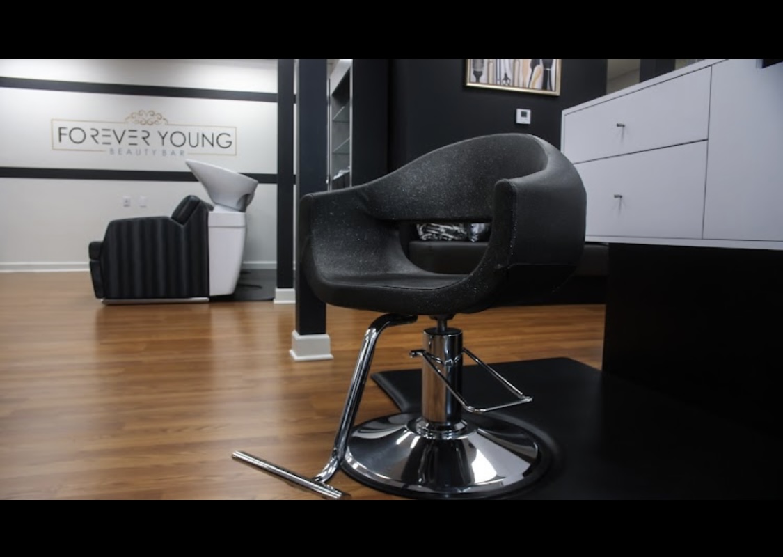 Comfortable black salon chair in a stylish hair salon interior.