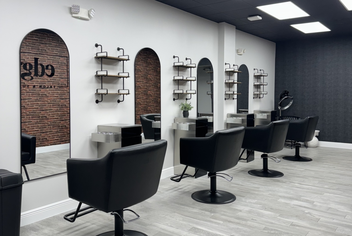 Stylish salon chairs with mirrors and shelving in a trendy salon space.