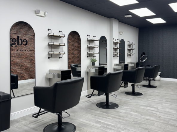 Stylish salon chairs with mirrors and shelving in a trendy salon space.