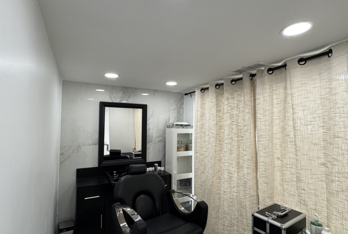 Modern salon chair with mirror and professional amenities for stylists.