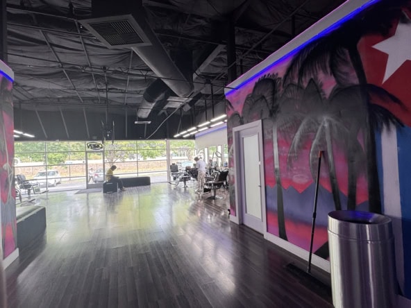 Bright modern salon interior with hair stations, large windows, and vibrant wall art, ideal for salon rentals and styling services.