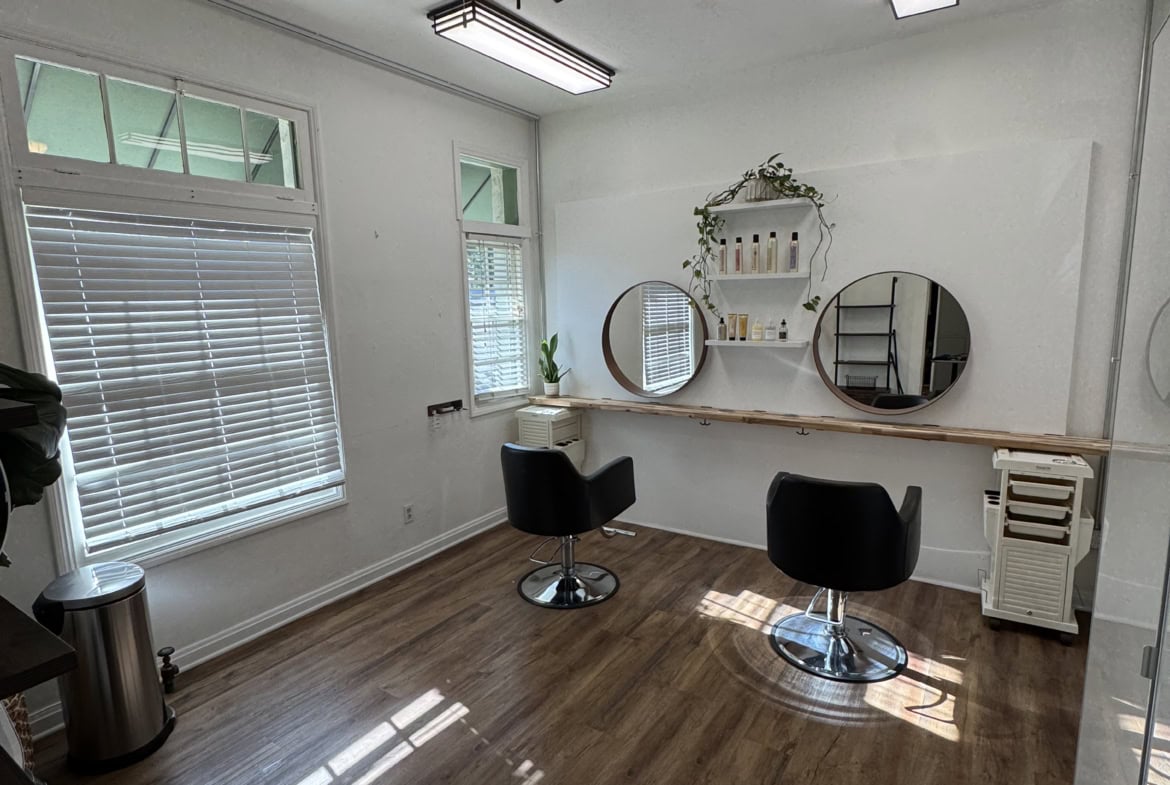 Modern salon studio with stylish decor and large windows for rent on Salon Renter platform.