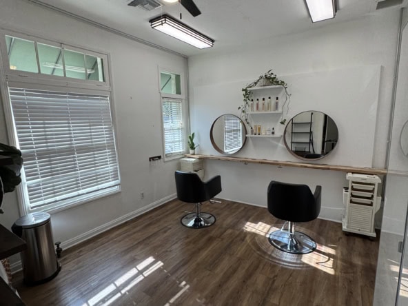 Modern salon studio with stylish decor and large windows for rent on Salon Renter platform.
