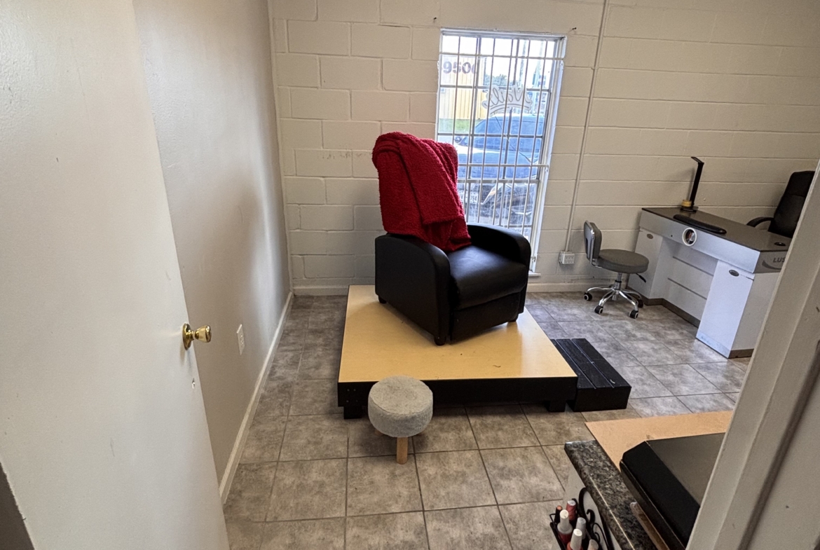 Cozy salon break room with chair, window, and nail polish display for rent opportunities.