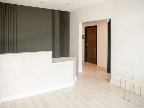 Contemporary salon reception with stylish white marble counter and clean interior.