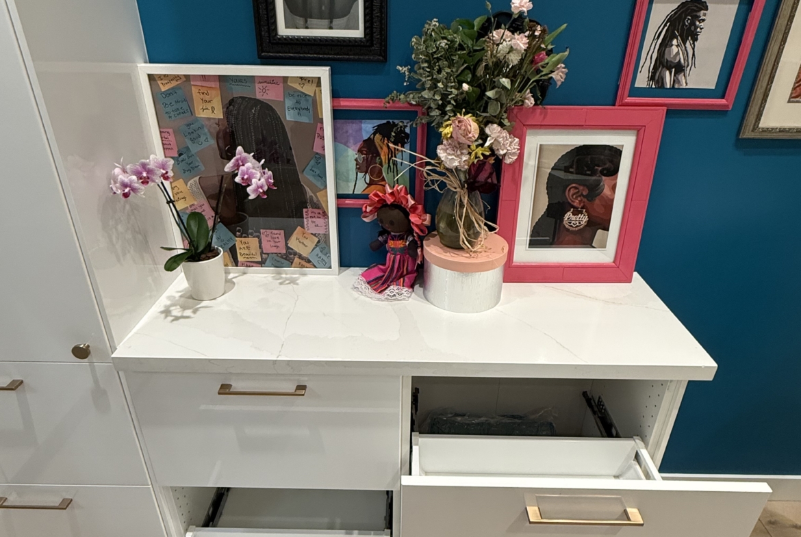 Vibrant salon decor featuring framed artwork, pink accents, and floral arrangements for a stylish salon space.