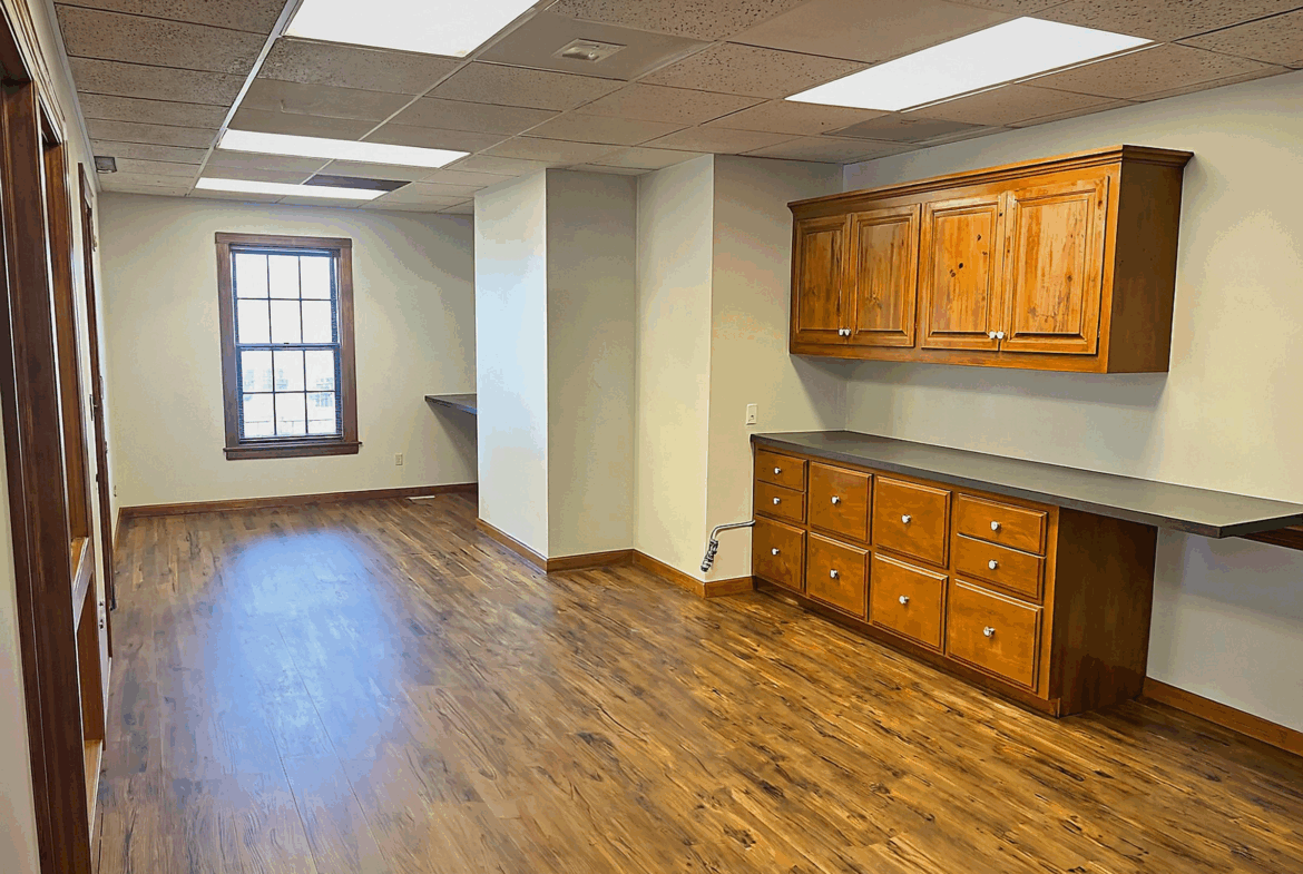 Spacious salon interior with natural light, wooden cabinets, and flooring, perfect for beauty professionals.