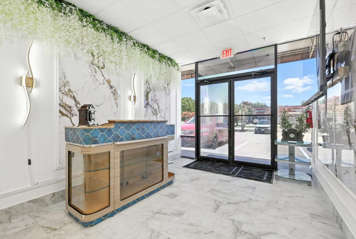 Bright salon interior with marble accents, decor, and glass doors.