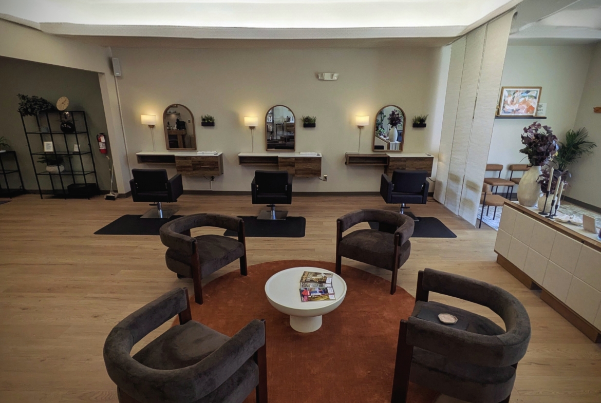 Stylish salon space featuring hair styling stations, mirrors, and cozy seating area for clients.