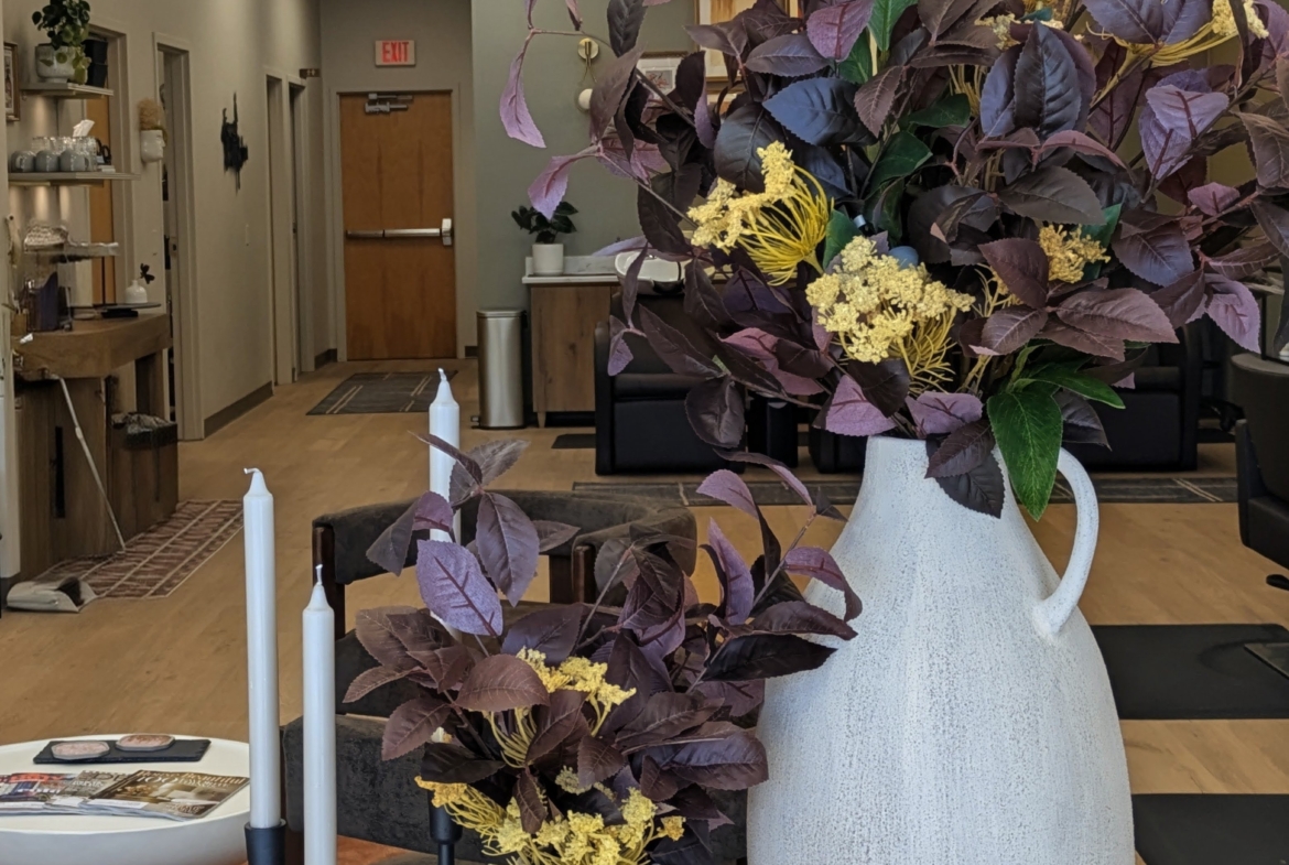 Beautiful large and small vases with purple foliage and yellow accents in a salon interior.