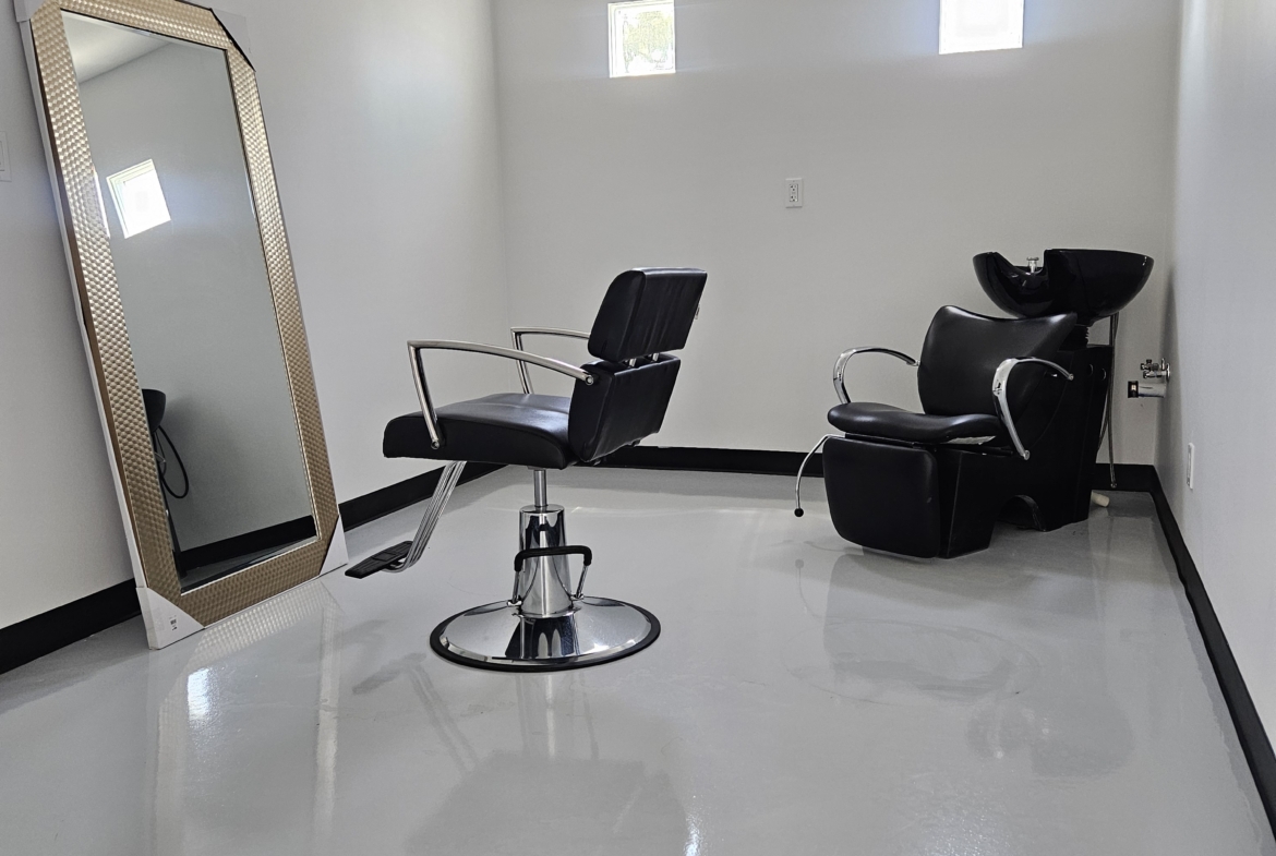 Bright, minimalist salon with styling chair and wash basin, ideal for beauty professionals.