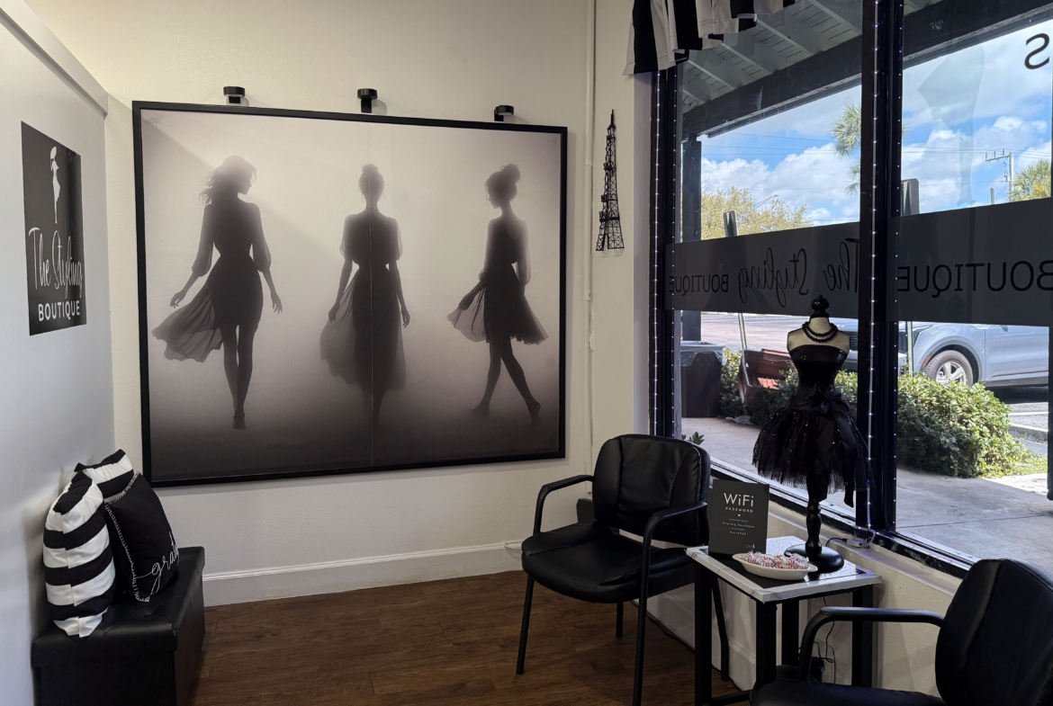 Modern salon waiting area with black chairs, fashion art, and boutique decor.