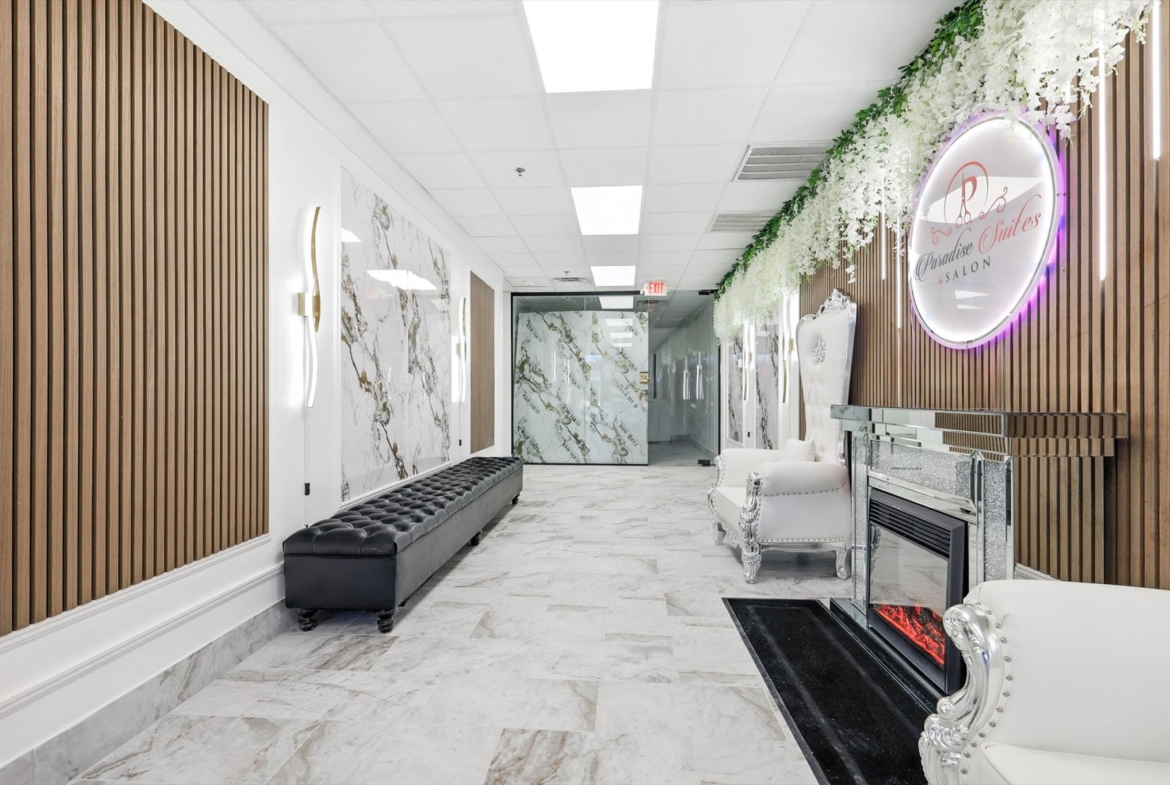Elegant salon lounge featuring marble accents, cozy seating, and a stylish ambiance.