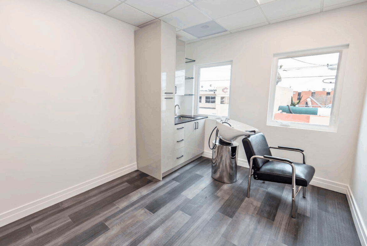 Bright salon space with modern styling chairs, sink, and ample natural light, perfect for salon renters.