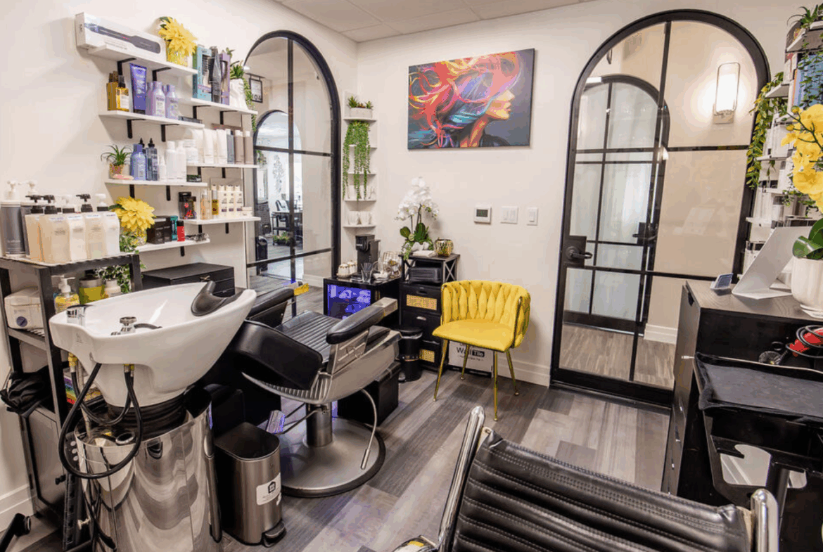 Sophisticated salon space with styling stations, products, and vibrant artwork, perfect for beauty professionals.
