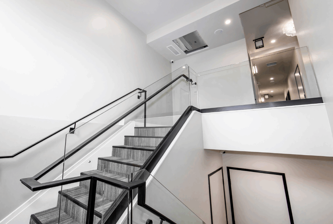 Modern salon space with sleek staircase, clean design, perfect for salon rentals and hairstyling businesses.
