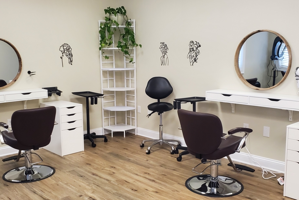 Stylish salon station with mirrors, chairs, and decorative wall art for hair styling services.