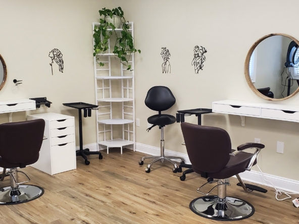 Elegant hair salon station with mirrors and modern furniture.