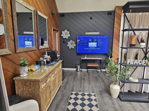 Bright salon awaiting area with wood-paneled walls, decorative flowers, and comfortable seating.