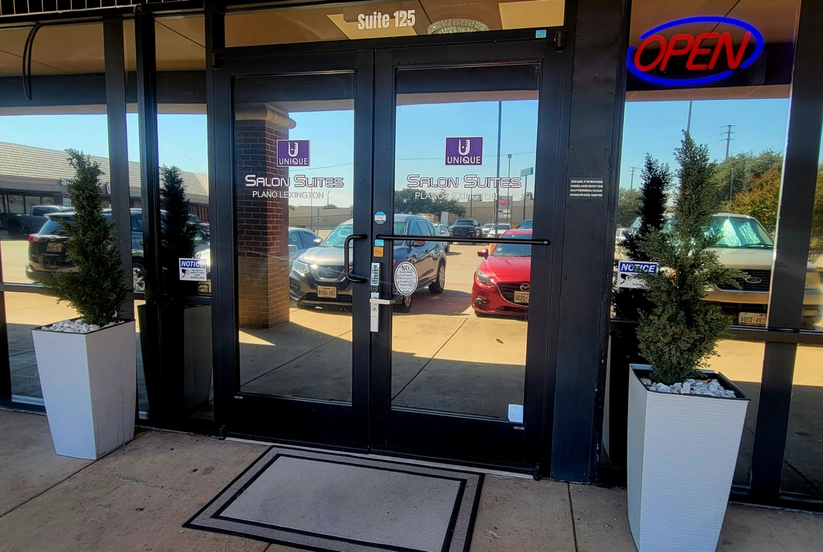 Bright salon suite entrance with welcoming "Open" sign and modern decor.