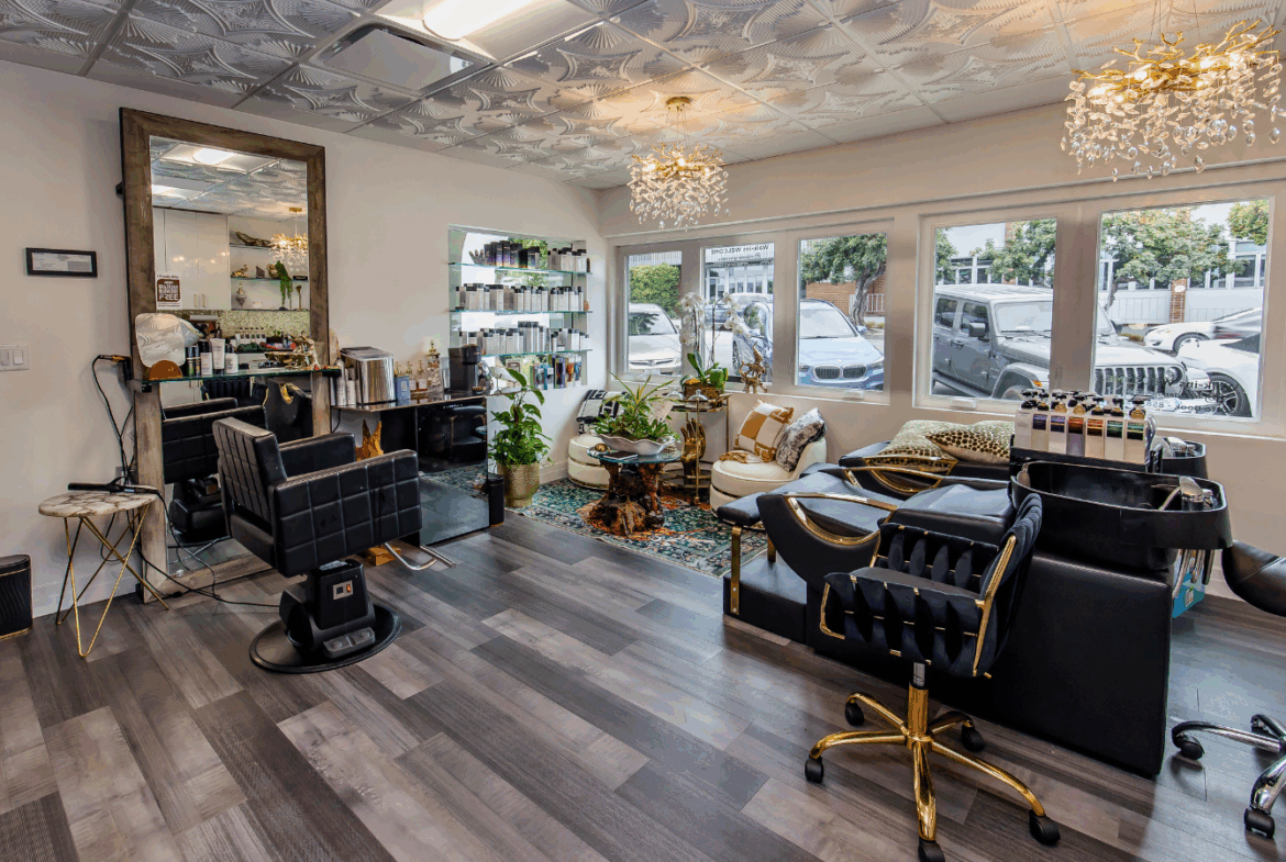 Bright hair salon with modern styling chairs, decor, and large windows for natural light.