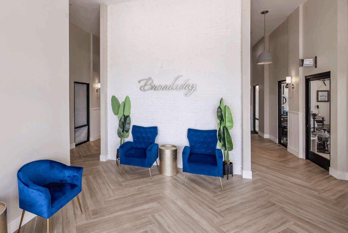 Stylish salon interior with comfy blue chairs and decorative plants for a relaxing vibe.