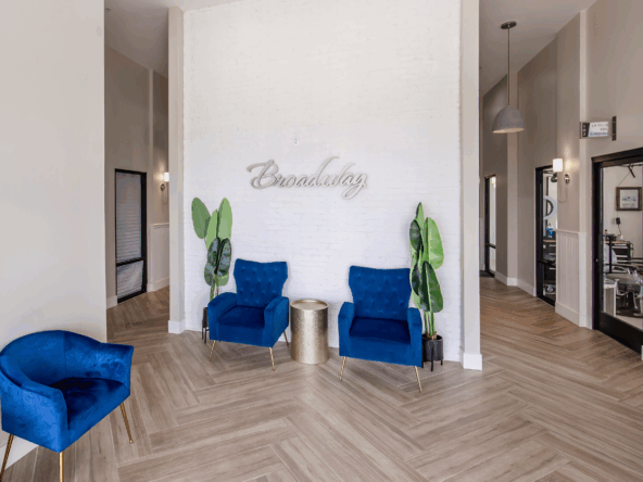 Stylish salon interior with comfy blue chairs and decorative plants for a relaxing vibe.